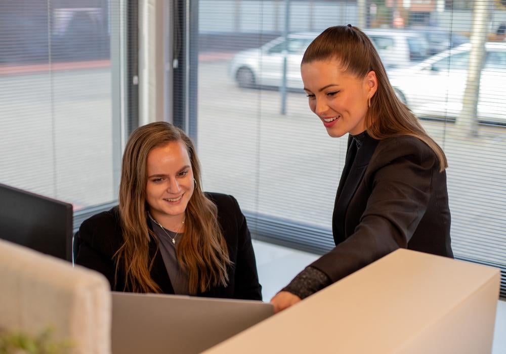 Collega's werken samen achter laptop